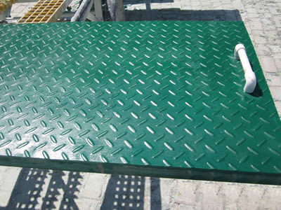 A piece of covered FRP grating with plastic handle on the working station.
