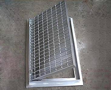 A drainage trench box grate with hinges and smooth surface.