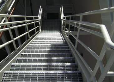 Several stair treads are made of plain steel grating.