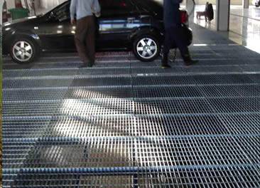 A plain steel grating parking lot and a car is parking on it.