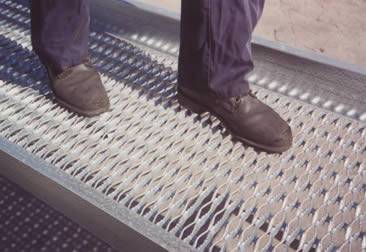 A man is walking on the diamond safety grating walkway.