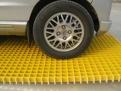A heavy vehicles is passing on the yellow color FRP molded grating.