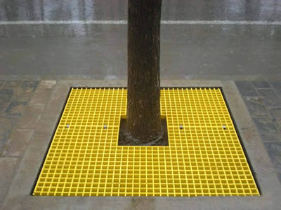Yellow FRP molded grating is installed around the tree.