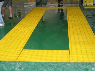 Yellow FRP pultruded grating is installed on the ground of car wash shop.