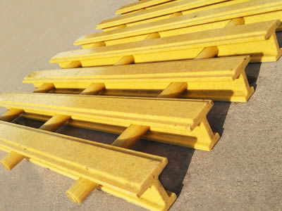 A piece of yellow color FRP pultruded grating with convex surface on the gray background.