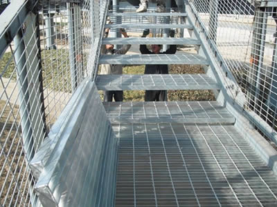 Galvanized steel gratings are installed on the stair treads and walkway.