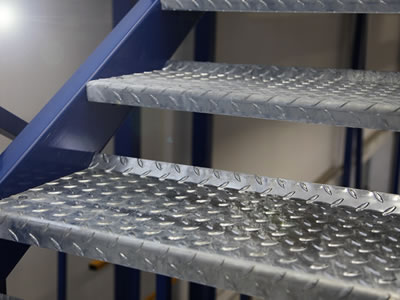 A stair treads are installed with metal open bar steel grating with chequer plate.