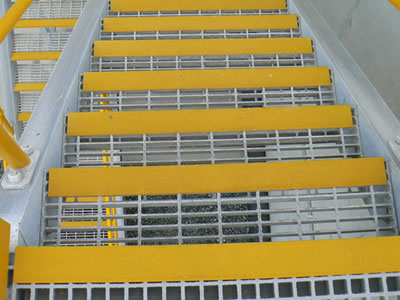A GRP molded grating stair treads with yellow color gritted plate nosing.