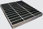 A serrated steel grating is made of galvanized steel bars.