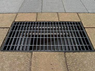 A welded steel grating is installed on the ground.